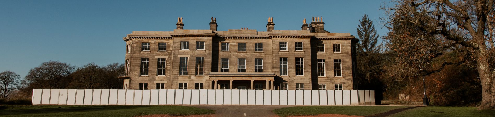 Historic hall with white fencing in front